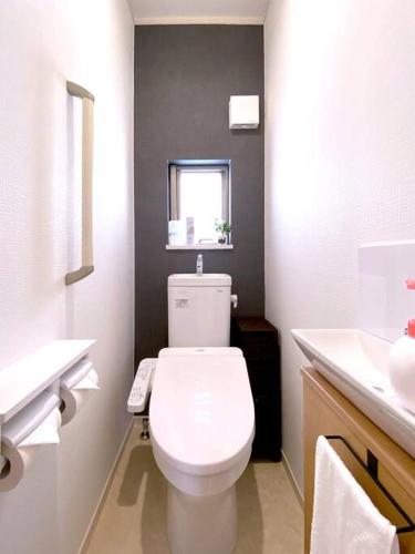 a bathroom with a white toilet and a sink at 海まで3分！アメリカンビレッジまで5分 最大8名 Moana in Chatan