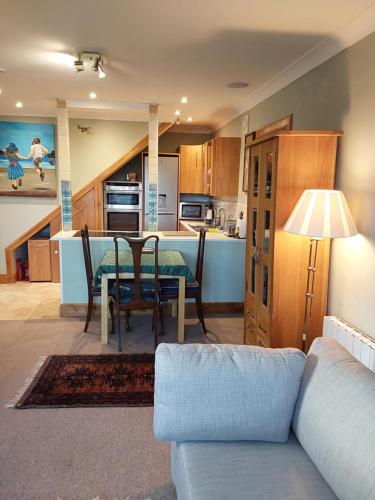 a kitchen and dining room with a table and a couch at Ceol Na Mara (Music of the Sea) in Rosemarkie