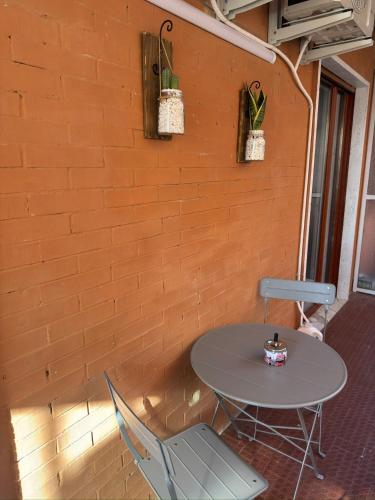 a table and chairs in front of a brick wall at Cliò guest house in Ercolano