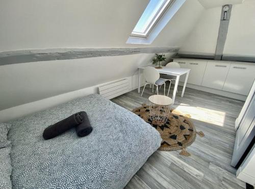 a living room with a bed and a table at PETIT CROIX in Rouen