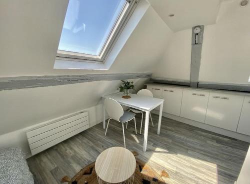 une cuisine blanche avec une table et une fenêtre dans l'établissement PETIT CROIX, à Rouen