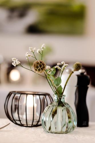 a glass vase with flowers in it on a table at Landhaus Lauble in Hornberg