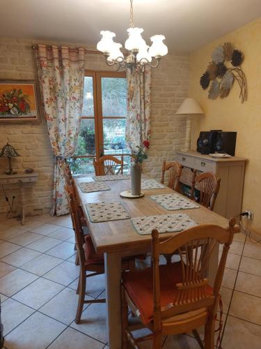 une salle à manger avec une table et des chaises en bois dans l'établissement Maison de campagne près d'un plan d'eau et des belles forêts !, à Pargny-Filain
