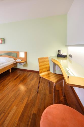 a room with a desk and a bed and a desk and chair at Ramada by Wyndham Baden Hotel du Parc in Baden