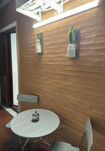 a table and chairs in front of a brick wall at Cliò guest house in Ercolano