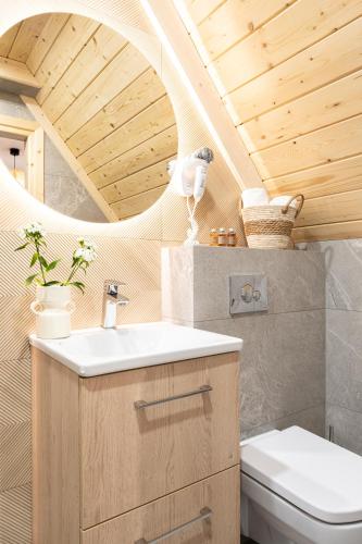 a bathroom with a sink and a wooden ceiling at Highlander Heart Residence in Zakopane