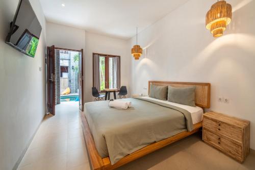 a bedroom with a large bed and a tv at Gelatik Bed And Breakfast in Seminyak