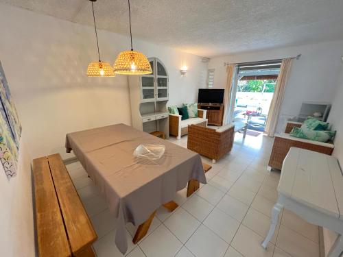 a dining room with a table and a living room at Kenville in Bain Boeuf