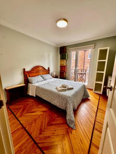 1 dormitorio con 1 cama y suelo de madera en Vista Catedral Vivienda con gran encanto Burgos Vut 579 ATUAIRE, en Burgos