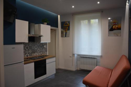 a kitchen with white cabinets and a blue wall at Poseidon's refuge in La Spezia