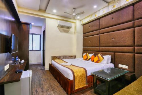 une chambre d'hôtel avec un lit et une télévision dans l'établissement The Ashoka Hotel, à Indore