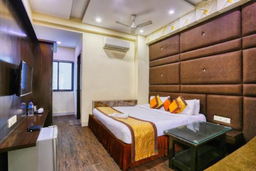 a hotel room with a bed and a television at The Ashoka Hotel in Indore