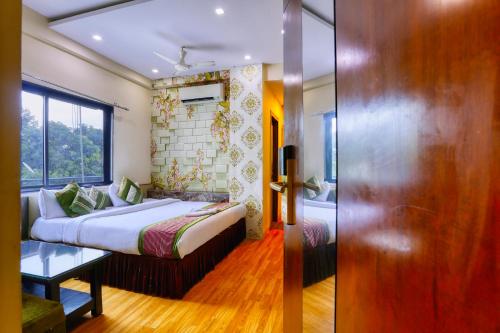 una camera d'albergo con un letto e una porta scorrevole di The Ashoka Hotel a Indore
