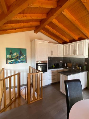 a kitchen with white cabinets and a wooden ceiling at CasaBruno in Arcos de Valdevez
