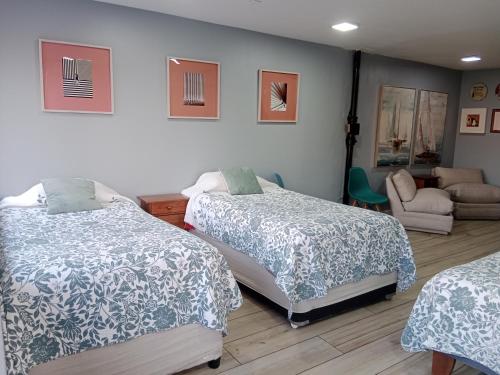 1 dormitorio con 2 camas, silla y sofá en Providencia Departamento A Pasos Costanera Center, en Santiago