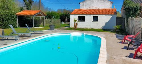 a swimming pool in front of a house at Le petit logement de la postière in La Garnache
