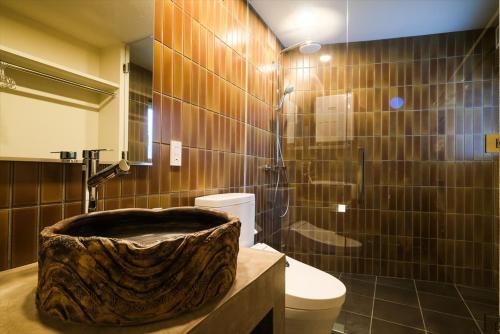 a bathroom with a large wooden tub in a bathroom at RIVERSIDE TERRACE OKINAWA KADENA in Kadena
