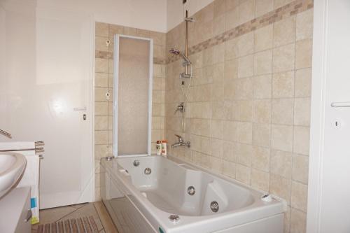 a white bath tub in a bathroom with a sink at Bergamum F.L. in Bergamo