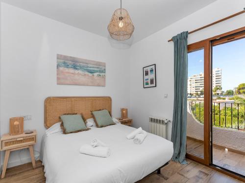 1 dormitorio con cama blanca y balcón en Mediterranean tropical house, en El Campello