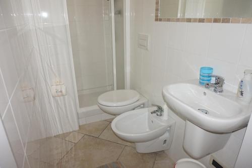 a white bathroom with a toilet and a sink at Bergamum F.L. in Bergamo