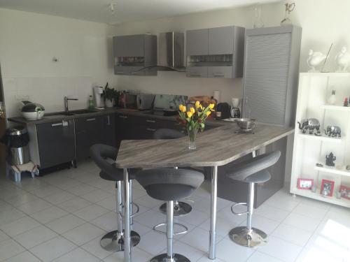 a kitchen with a table with a vase of flowers on it at Chambre confortable chez l'habitant in Saint-Laurent