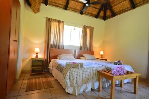 um quarto com uma cama grande e uma janela em Tamanini Timbavati Lodge em Hoedspruit
