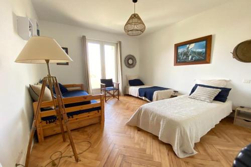une chambre avec un lit et une chaise dedans dans l'établissement Grand appartement 3 chambres vue mer Pontaillac, à Royan