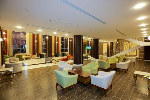 a lobby of a hotel with chairs and tables at Tulip Plaza By LPC Hotels & Resorts in Hafr Al Baten