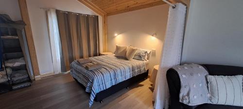 a small bedroom with a bed and a window at Meander Country Cabins in Meander