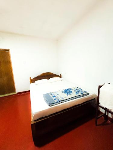 a bedroom with a bed and a chair in it at Knuckles Home Stay in Rattota