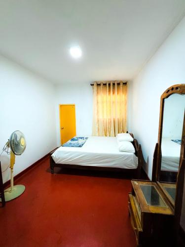 a bedroom with a bed and a mirror in it at Knuckles Home Stay in Rattota