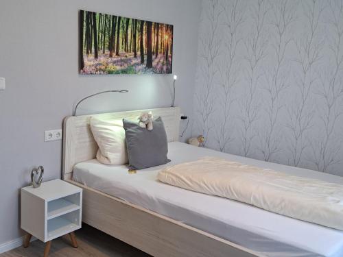 a bedroom with a bed and a painting on the wall at Dat lütte Heidehotel Funk - Garni in Bispingen