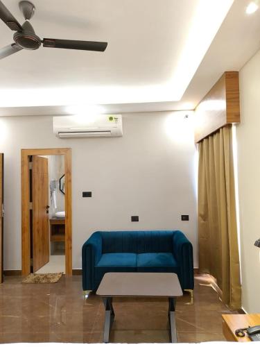 a blue couch in a living room with a ceiling at BANMALI REGENCY in Jamshedpur