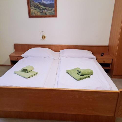 a bed with two green towels on top of it at Almgasthof Spitzer in Sankt Stefan ob Leoben