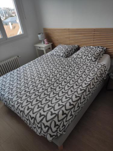 1 cama con edredón blanco y negro en un dormitorio en Maria’s place, en Rueil-Malmaison