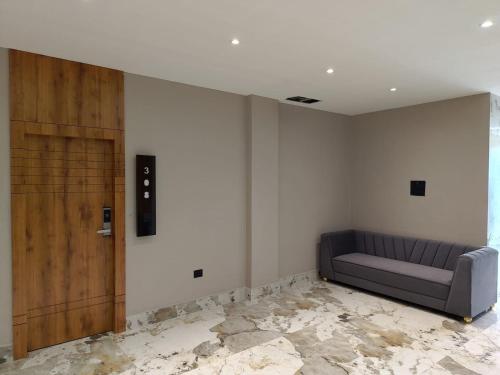 a room with a couch and a wooden door at BANMALI REGENCY in Jamshedpur
