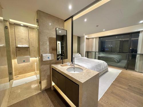 a bathroom with a sink and a bed in a room at ZHome-Deplex luxury apartment-Near The Bund in Shanghai