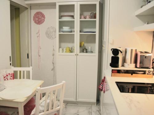 a white cabinet in a kitchen with a table at ViLLETTA CLAUDETTA in Laveno-Mombello