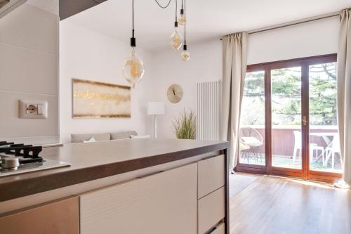 uma cozinha com armários brancos e uma grande janela em Boutiqueapartment Lago em Bardolino