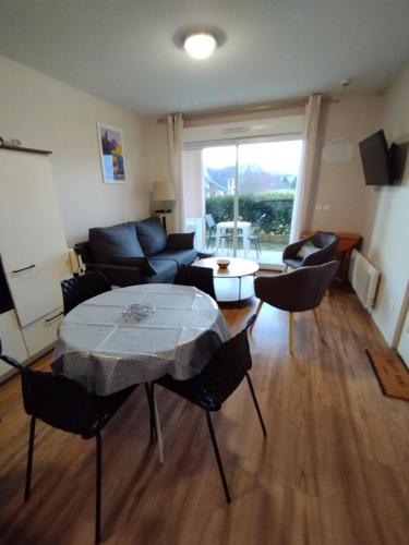 un salon avec une table et un canapé dans l'établissement Appartement 3 étoiles, 2 chambres , cuisine aménagée, terrasse, face à la chaîne des Pyrénées, à Bagnères-de-Bigorre