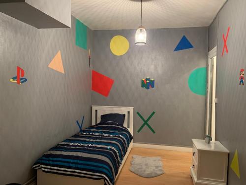- une chambre avec un lit et des murs colorés dans l'établissement Logement entier 100 m2, à Sin-le-Noble