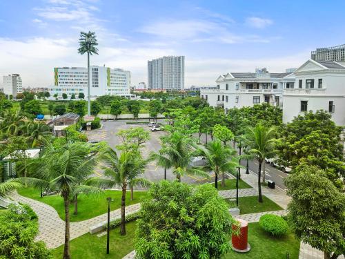vistas a un parque con palmeras y edificios en CHLOE'S SERVICED APARTMENT - VINHOMES MARINA, en Xóm Niêm