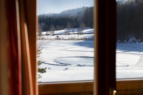 a view of a snow covered field from a window at Parkhotel Tristachersee in Lienz