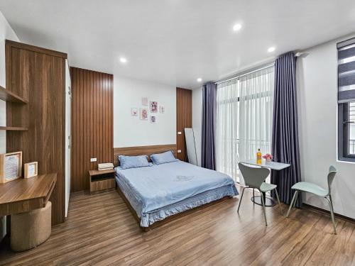 1 dormitorio con cama, escritorio y mesa en CHLOE'S SERVICED APARTMENT - VINHOMES MARINA, en Xóm Niêm