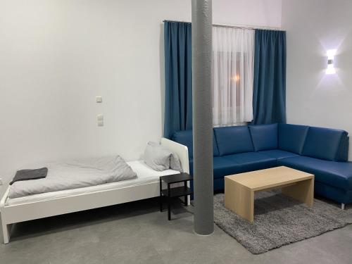 1 dormitorio con 1 cama y 1 sofá azul en Fabella Flats Forchheim, en Forchheim