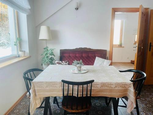 une table à manger avec quatre chaises, une table et une table dans l'établissement Krasnogruda 7c, à Sejny