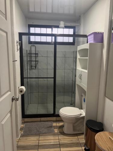 a bathroom with a glass shower with a toilet at Villa bonita in Puerto Jiménez