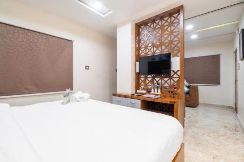 a bedroom with a bed and a flat screen tv at HOTEL SM PARADISE in Visakhapatnam