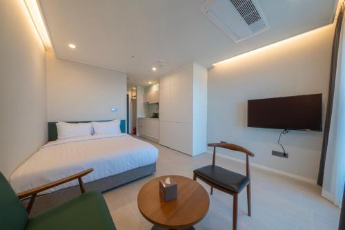 a hotel room with a bed and a tv at Chestertons Naksan in Yangyang