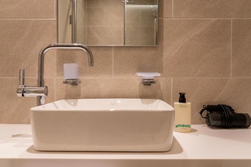 a white sink in a bathroom with a mirror at Chestertons Naksan in Yangyang